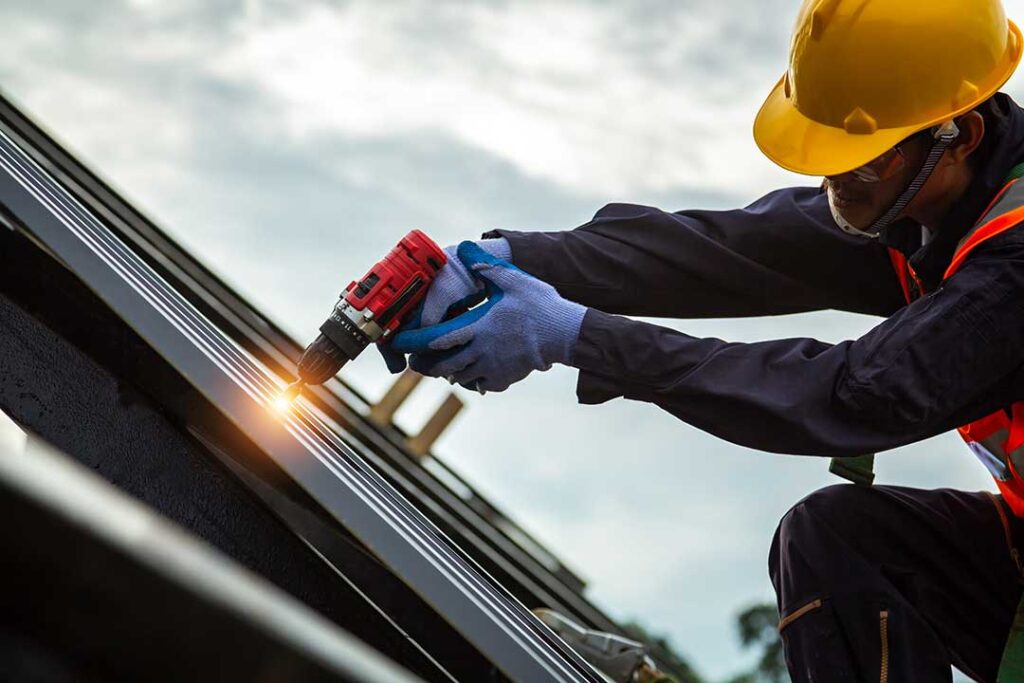 A soccer ball rests beside a cracked roof shingle while a homeowner examines the damage from the ground.