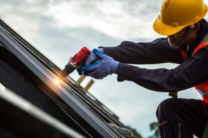 A soccer ball rests beside a cracked roof shingle while a homeowner examines the damage from the ground.