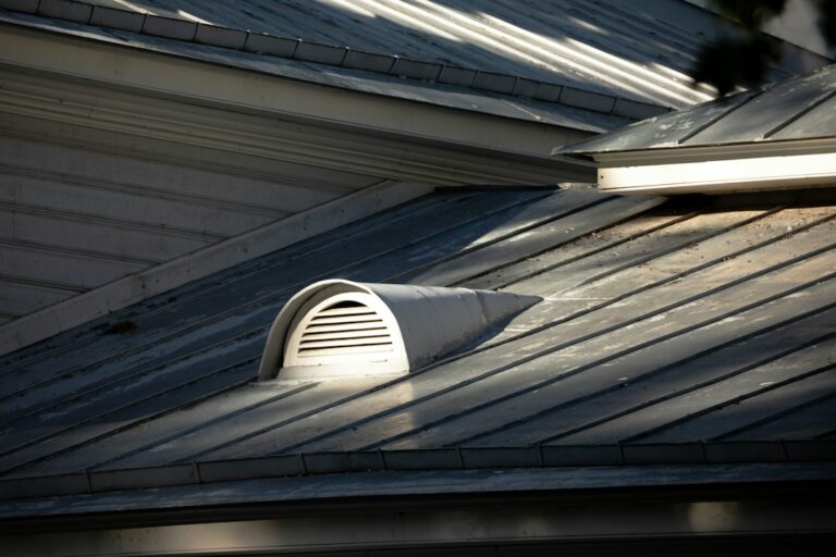 Rain falls on a residential roof while insulated attic space and ceiling materials reduce sound indoors.